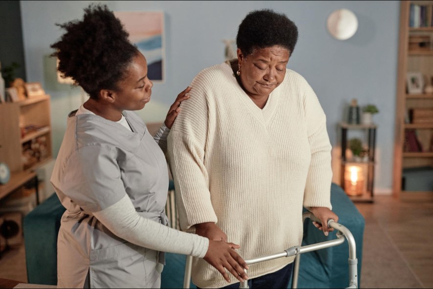 Caregiver holding hands with senior at home